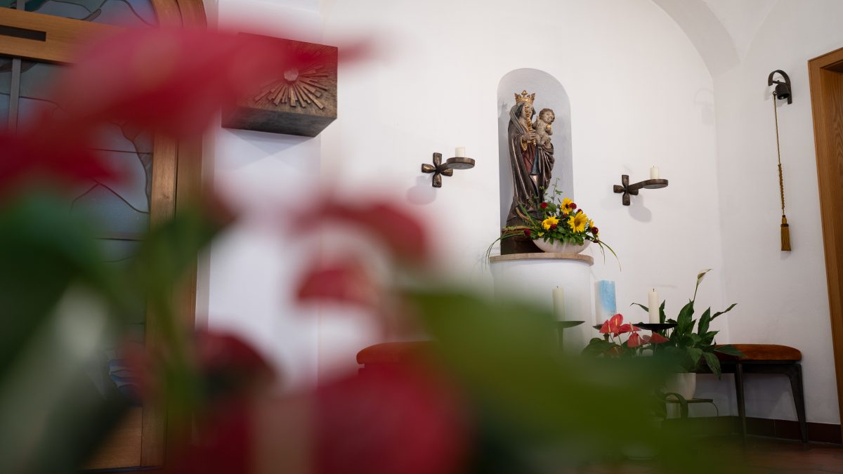 Blick auf die mit Blumen geschmückte Marien-Statue in der hauseigenen Kapelle.